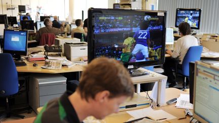 Des journalistes de l'AFP regardent un match entre le Japon et le Cameroun lors de la Coupe du monde 2010 en Afrique du Sud,&nbsp;le 14 juin 2010 à Paris. (FRED DUFOUR / AFP)