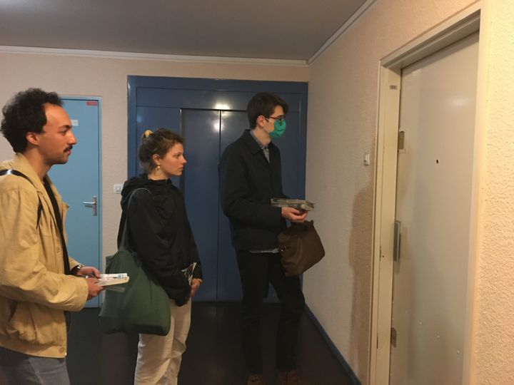 Corentin, Lena et Fabien, soutiens de Yannick Jadot, font face à une porte close dans une résidence du 14e arrondissement de Paris, le 30 mars 2022. (MARGAUX DUGUET / FRANCEINFO)