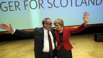 La nouvelle dirigeante du Parti national écossais Nicola Sturgeon et Christian Allard, membre du Parlement écossais d'origine française pour le nord-est de l'Écosse saluent le public après qu'elle a prononcé son premier discours liminaire à la conférence du SNP à Perth, en Écosse. (ANDY BUCHANAN / AFP)