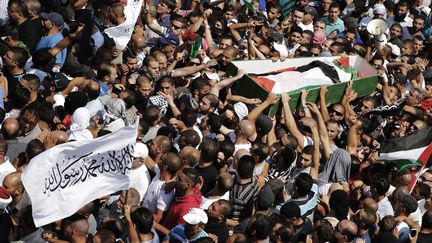 La foule transporte le cercueil de l'adolescent palestinien assassin&eacute;, le 4 juillet 2014, dans un quartier de J&eacute;rusalem-Est. (FINBARR O'REILLY / REUTERS)