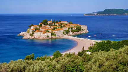 La côte Adriatique, la baie de Budva et l'Ile de Sveti Stefan, haut lieu du tourisme au Montenegro. Autrefois un village de pêcheurs, aujourd'hui un luxueux complexe hôtelier. (Illustration) (TUUL & BRUNO MORANDI / THE IMAGE BANK RF / GETTY IMAGES)