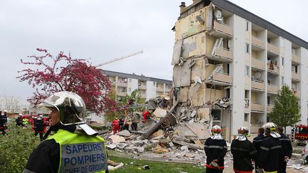 Des pompiers travaillent sur le site de l'effondrement d'un pan d'immeuble, le 28 avril 2013, &agrave; Reims (Marne). (FRANCOIS NASCIMBENI / AFP)