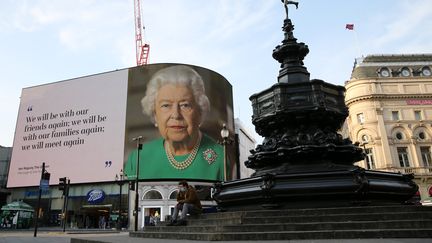 Un message de la reine Elizabeth II à propos de l'épidémie de coronavirus est affiché à Picadilly Circus, à Londres, le 9 avril 2020. (ISABEL INFANTES / AFP)