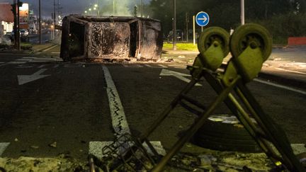 Une voiture a été brûlée sur une route à Fort-de-France, le 23 novembre 2021, lors de blocages contre le pass sanitaire et l'obligation vaccinale.&nbsp; (LOIC VENANCE / AFP)