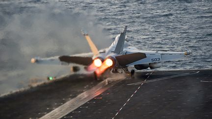 Un avion de chasse am&eacute;ricain d&eacute;colle du porte-avion "USS Carl Vinson", dans le golfe d'Arabie, pour aller effectuer des frappes a&eacute;riennes en Syrie, le 28 octobre 2014. (US NAVY / REUTERS)