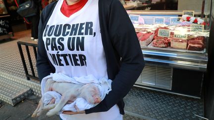 Une militante antispéciste manifeste devant une boucherie, à Paris, le 22 septembre 2018. (JACQUES DEMARTHON / AFP)