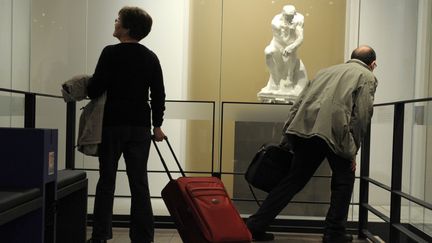 Des passagers passent devant "Le Penseur" de Rodin dans l'espace culturel de l'aéroport de Roissy Charles-de-Gaulle.
 (ERIC PIERMONT / AFP)