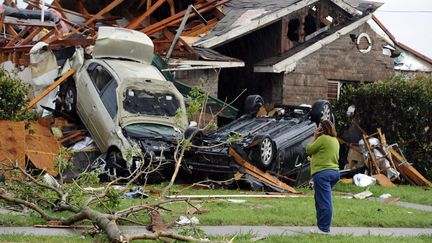 Une femme t&eacute;l&eacute;phone en observant les d&eacute;g&acirc;ts caus&eacute;s par une tornade, &agrave; Dallas, au Texas&nbsp;(Etats-Unis), le 3 avril 2012. (LARRY W. SMITH / MAXPPP)