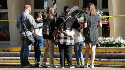 Des habitants déposent des fleurs devant le lycée Gambetta, à Arras (Pas-de-Calais), le samedi 14 octobre 2023. (DENIS CHARLET / AFP)