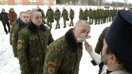 Des soldats bi&eacute;lorusses font la queue pour embrasser &agrave; tour de r&ocirc;le une croix orthodoxe sur une base militaire de Minsk (Bi&eacute;lorussie), le 7 janvier 2013. (VASILY FEDOSENKO / REUTERS)