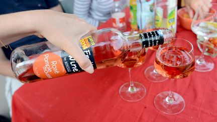 Une personne se sert un verre de rosé-pamplemousse, l'un des "premix" à base de vin.&nbsp; (MARC OLLIVIER / MAXPPP)