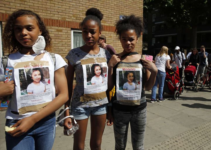 Des jeunes filles arborent, le 15 juin 2017, des photos de Jessica Urbano, portée disparue depuis l'incendie de la tour Grenfell.&nbsp; (ALASTAIR GRANT/AP/SIPA / AP)