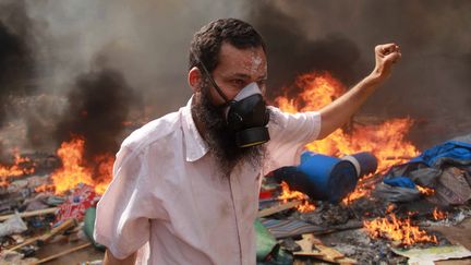 Un manifestant pro-Morsi durant les affrontements meurtriers avec la police au Caire (Egypte), le 14 ao&ucirc;t 2013. (MOSAAB EL-SHAMY / REUTERS)