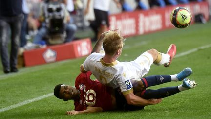 Kasper Dolberg&nbsp;s'écroule sur Reinildo lors de la large victoire de Nice sur la pelouse de Lille, le 14 août.&nbsp; (FRANCOIS LO PRESTI / AFP)