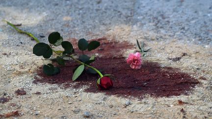 Des fleurs d&eacute;pos&eacute;es dans une flaque de sang devant le mus&eacute;e du Bardo, le 19 mars 2015,&nbsp;&agrave; Tunis (Tunisie), apr&egrave;s l'attaque terroriste qui a fait 21 morts. (FADEL SENNA / AFP)