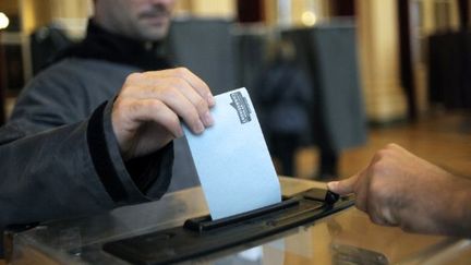 Vote dimanche dans un bureau de vote parisien. (JEFF PACHOUD / AFP)