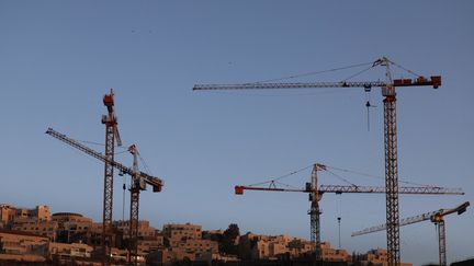 Des grues à l'arrêt sur un chantier de construction près de Jérusalem, en septembre 2022. Photo d'illustration (AHMAD GHARABLI / AFP)