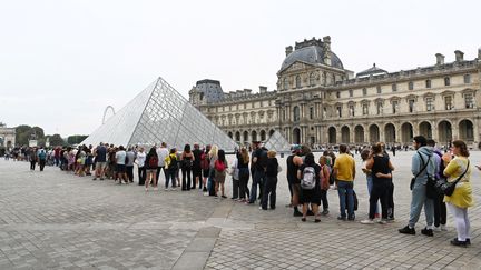 La file de visiteurs pour visiter le musée du Louvre, en août 2022. (STEFANO RELLANDINI / AFP)