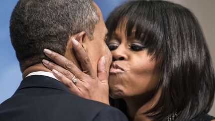 Le pr&eacute;sident am&eacute;ricain, Barack Obama, est embrass&eacute; par son &eacute;pouse Michelle lors de la c&eacute;r&eacute;monie de son investiture &agrave; Washington (Etats-Unis), le 20 janvier 2013. (BRENDAN SMIALOWSKI / AFP)