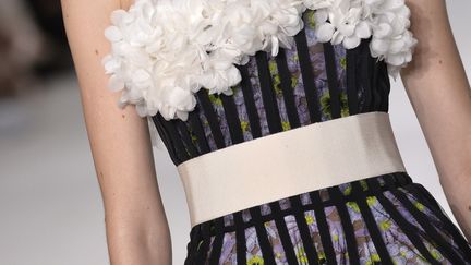 Les premières silhouettes renvoient à un chic italien, celui de la Dolce Vita. Les jupes crayons s'arrêtent sous le genou. Giambattista Valli privilégie les rayures, noires et blanches, soulignées parfois par des paillettes. Puis les fleurs prennent le dessus. Elles sont surtout brodées, comme des marguerites et des glycine qui recouvrent des silhouettes. Elles peuvent être imprimées aussi. Côté soir, des robes bustier, des robes godet, des robes chemisier mais aussi des robes de bal avec tulle volanté et plumes d'autruche.  
 (MIGUEL MEDINA)