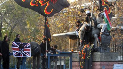 Des Iraniens s'attaquent &agrave; la cl&ocirc;ture de l'ambassade britannique &agrave; T&eacute;h&eacute;ran (Iran) le 29 novembre 2011. (ATTA KENARE / AFP)