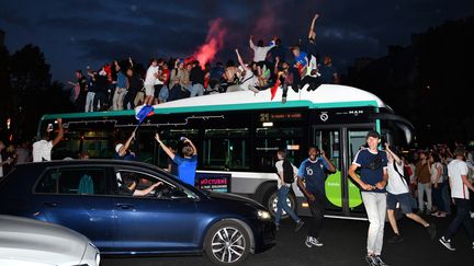 Massés sur un bus, des supporters français fêtent la victoire de la France face à la Belgique, le 10 juillet 2018, à Paris. (MUSTAFA YALCIN / ANADOLU AGENCY / AFP)