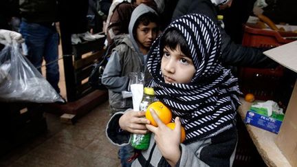 reçoit de la nourriture distribuée par l'Eglise orthodoxe de Grèce à Athènes, le 22 Décembre 2011. 

La soupe populaire devient pour beaucoup l’ultime moyen de pouvoir nourrir sa famille. (REUTERS/Yiorgos Karahalis )