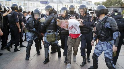 Des policiers anti-émeute arrêtent des manifestants,&nbsp;à Moscou, le 27 juillet 2019, lors d'un rassemblement non-autorisé demandant aux candidats indépendants et à l'opposition de se présenter aux élections locales de septembre. (MAXIM ZMEYEV / AFP)