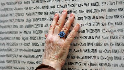 Le Mémorial de la&nbsp;Shoah&nbsp;et la&nbsp;plateforme Bâtisseurs de mémoire&nbsp;viennent de lancer un appel aux dons pour le mur des noms. Ci-contre, une personne recherche un nom, le 27 janvier 2005 dans le Mémorial de la Shoah à Paris, au premier jour de son ouverture au public. Illustration. (JOEL SAGET / AFP)