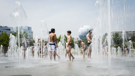 Des Parisiens se rafra&icirc;chissent dans les fontaines du parc Andr&eacute;-Citro&euml;n, &agrave; Paris, le 3 juillet 2015. (MAXPPP)