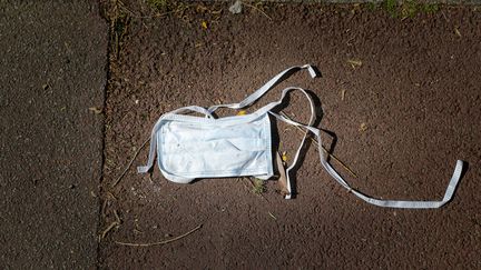 Un masque de protection laissé sur un trottoir après utilisation, le 10 avril 2020 à Roncq (Hauts-de-France) (THIERRY THOREL / MAXPPP)