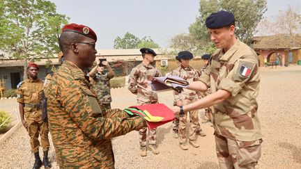 Des officiers supérieurs des forces burkinabaises et françaises lors d'une cérémonie de descente du drapeau marquant la fin des opérations de l'armée française au Burkina Faso au damp de Bila Zagré à Kamboincin, le 18 février 2023. (THE GENERAL STAFF OF THE ARMED FORCES OF BURKINA FASO / AFP)