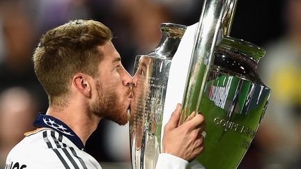 Le joueur du Real Madrid Sergio Ramos embrasse le troph&eacute;e de la Ligue des champions, le 24 mai 2014 au stade de la Luz, &agrave; Lisbonne (Portugal). (LAURENCE GRIFFITHS / GETTY IMAGES EUROPE)