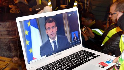 Un groupe de "gilets jaunes" regarde sur internet l'allocution du chef de l'Etat, le 10 décembre, à Rennes. (JOEL LE GALL / MAXPPP)