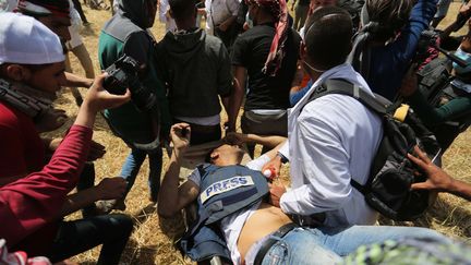 Yasser Mourtaja, un journaliste palestinien, transporté le 6 avril 2018, après avoir été mortellement blessé par balles par des soldats israéliens, lors d'une manifestation près de Khan Younès, dans la bande de Gaza.&nbsp; (ASHRAF AMRA / ANADOLU AGENCY / AFP)