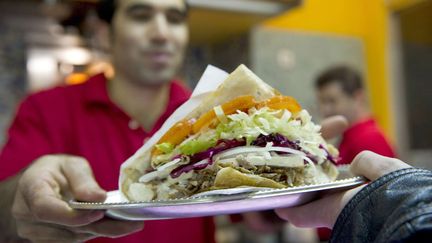 Un homme sert un d&ouml;ner kebab dans un restaurant &agrave; Berlin (Allemagne), le 21 mars 2010. (GERO BRELOER / AP / SIPA)