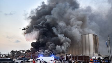 Un hélicoptère tente d'éteindre l'incendie&nbsp;après une explosion au port de Beyrouth au Liban, le 4 août 2020. (STR / AFP)