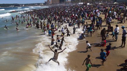 Des Sud-africains c&eacute;l&egrave;brent le Nouvel an sur la plage de Durban (Afrique du sud), le 1er janvier 2014. (ROGAN WARD / REUTERS)