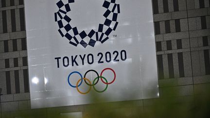 Le logo des Jeux olympiques 2020 est affiché sur un bâtiment de Tokyo (Japon), le 30 mars 2020. (PHILIP FONG / AFP)