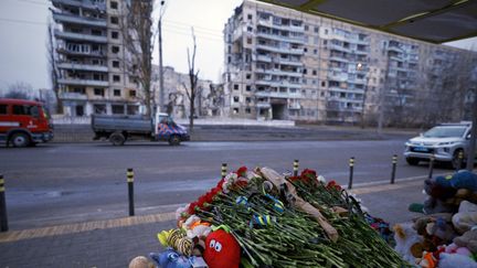 Des fleurs et des jouets déposés mardi 17 janvier en face d'un immeuble bombardé par les forces russes samedi 14 janvier à Dnipro, dans l'est de l'Ukraine. (VITALII MATOKHA / AFP)