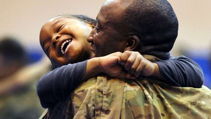 La joie de ce jeune gar&ccedil;on de 5 ans qui retrouve son p&egrave;re de retour d'Afghanistan &agrave; Anchorage (Alaska), le 17 septembre 2012. (BILL ROTH / AP / SIPA)