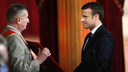 Emmanuel Macron se voit remettre le grand collier de l'ordre national de la Légion d'honneur de France par le grand chancelier de la Légion d'honneur, le général Benoit Puga, lors de sa cérémonie officielle d'investiture en tant que président français dans la salle des fêtes du palais présidentiel de l'Élysée à Paris, le 14 mai 2017.&nbsp;
 (FRANCOIS MORI / AFP)