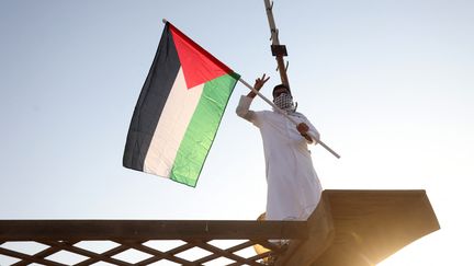 Un Koweïtien brandit le drapeau palestinien lors d'un rassemblement à Koweït City, le 7 octobre 2023. (YASSER AL-ZAYYAT / AFP)