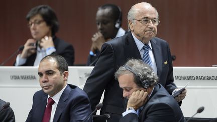 Le pr&eacute;sident de la Fifa, Sepp Blatter (C), passe &agrave; c&ocirc;t&eacute; de son concurrent, le prince Ali Ben Hussein (G), soutenu par le pr&eacute;sident de l'UEFA Michel Platini (D), le 29 mai 2015 &agrave; Zurich (Suisse). (FABRICE COFFRINI / AFP)