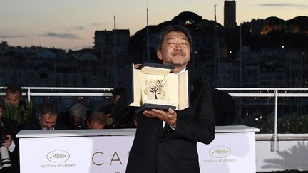 Hirokazu Kore-Eda, qui remporte la Palme d'or, pose avec son trophée le 19 mai 2018 à Cannes. (ANNE-CHRISTINE POUJOULAT / AFP)