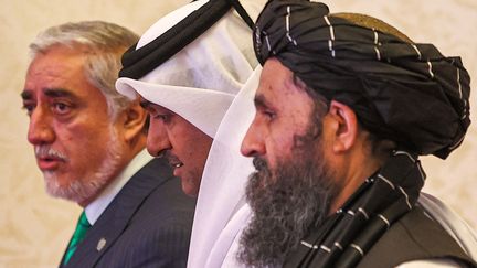 Le représentant du gouvernement afghan,&nbsp;Abdullah Abdullah (à gauche), et le négociateur en chef des talibans,&nbsp;Mullah Abdul Ghani Baradar (à droite), entourent le médiateur qatari&nbsp;Mutlaq al-Qahtani lors de pourparlers de paix à Doha (Qatar), le 18 juillet 2021. (KARIM JAAFAR / AFP)