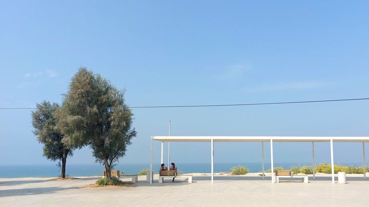 Agam assise avec sa mère devant le bord de mer désert d'Ashkelon (Israël) le 28 octobre 2023 (AGATHE MAHUET / FRANCEINFO / RADIO FRANCE)