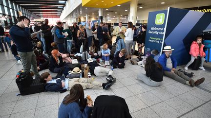 Des passagers attendent dans le terminal Nord de l'aéroport de Gatwick, près de Londres (Royaume-Uni) alors que les vols sont suspendus, le 20 décembre 2018. (GLYN KIRK / AFP)