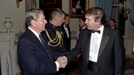 Le président américain de l'époque Ronald Regan et le milliardaire Donald Trump, à la Maison-Blanche, le 3 novembre 1987. (WHITE HOUSE / MAXPPP)