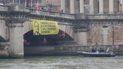 &nbsp; (La police tente d'enlever une des banderoles de Greenpeace près de l'Assemblée nationale © Radio France/Gérard Feldzer)